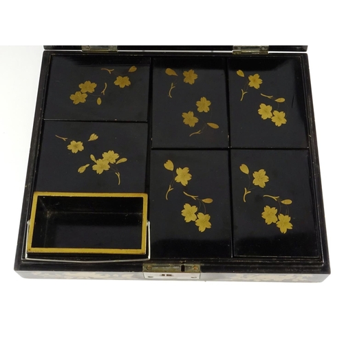 363 - Chinese black lacquer box, the hinged lid gilded with a landscape opening to reveal six boxes gilded... 