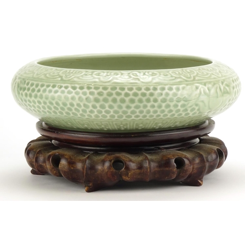 306 - Chinese celadon glazed squatted bowl, raised on a carved wood stand, six figure character marks to t... 