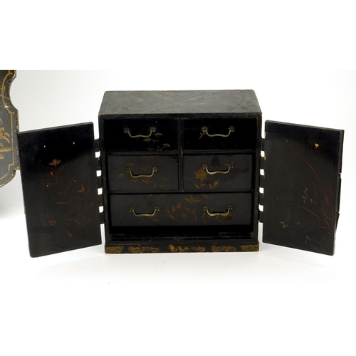 2109 - Japanese black lacquered table cabinet and a Chinese lacquered panel gilded with a figure before wat... 