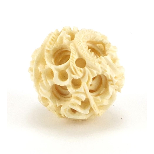 428 - Chinese carved ivory dragon puzzle ball, approximately 4cm in diameter