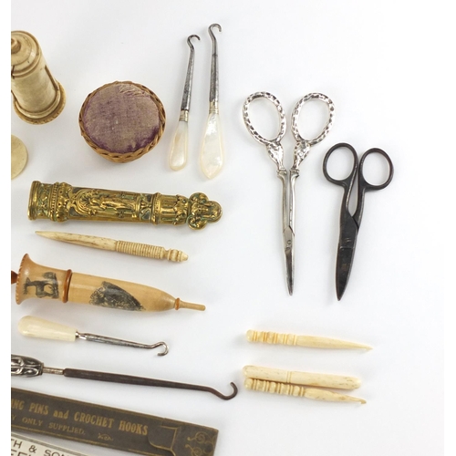 487 - Antique and later sewing items including a treen needle case, wicker basket, pin cushion and bone ne... 