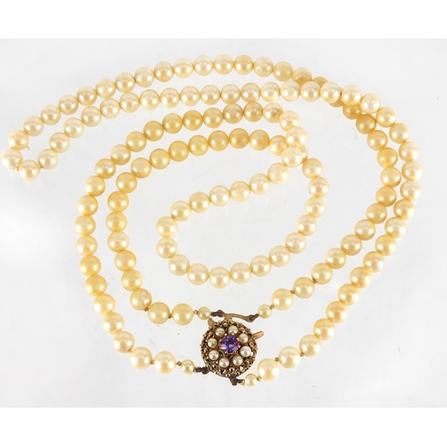 2669 - Simulated pearl two string necklace, with 9ct gold amethyst clasp, 44cm in length, approximate weigh... 