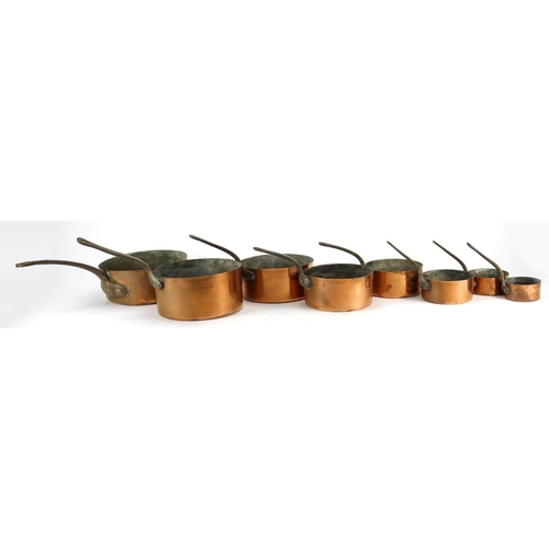 2389 - Graduated set of eight copper and wrought iron saucepans, the largest 44.5cm in length