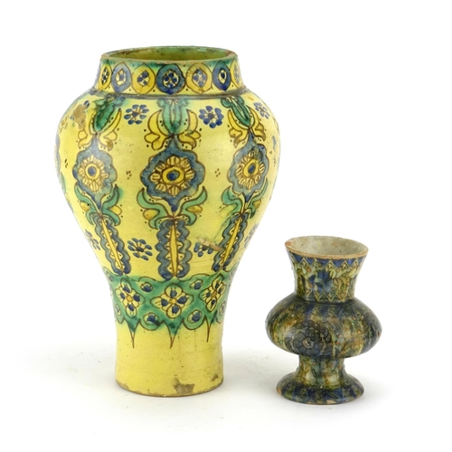 412 - Two Islamic pottery vases, each hand painted with flowers and foliage, the largest 27cm high