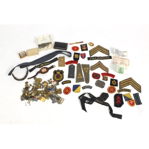 790 - Militaria including cloth patches, cap badges, pips and cap tallies