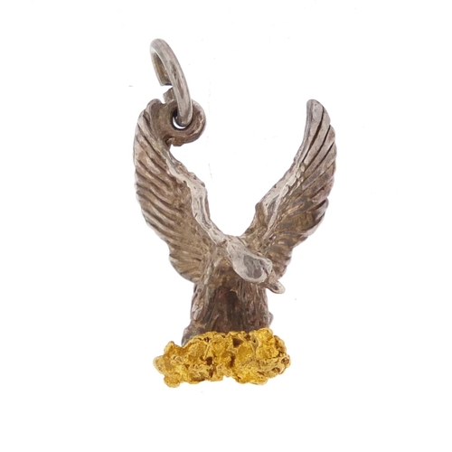 2667 - Silver eagle charm clutching a gold coloured nugget, 2cm in length, approximate weight 3.3g