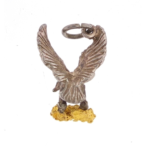 2667 - Silver eagle charm clutching a gold coloured nugget, 2cm in length, approximate weight 3.3g