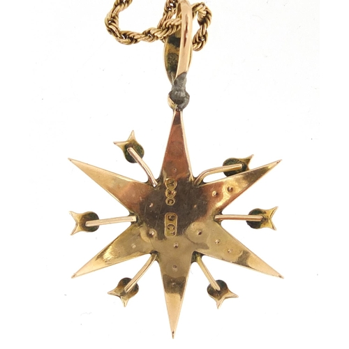 689 - 9ct gold seed pearl starburst pendant set with a central pink stone, on a 9ct gold rope twist neckla... 