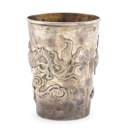 332 - Chinese silver cup and spoon, the cup with tapering body cast with a dragon chasing the flaming pear... 