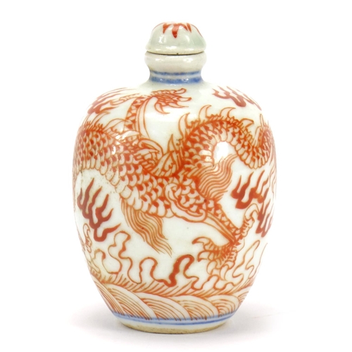 292 - Chinese porcelain iron red snuff bottle with stopper, hand painted with a dragon amongst clouds, blu... 