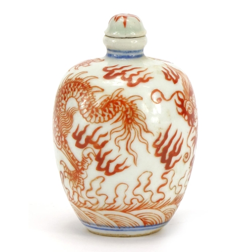 292 - Chinese porcelain iron red snuff bottle with stopper, hand painted with a dragon amongst clouds, blu... 