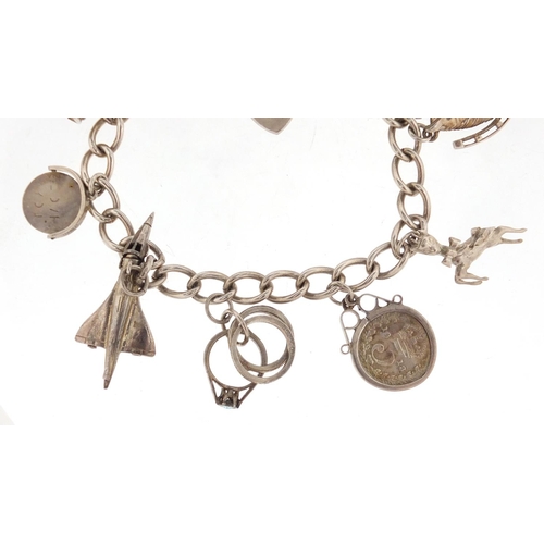 2835 - Silver charm bracelet with a selection of mostly silver charms including horse head, Concorde and a ... 