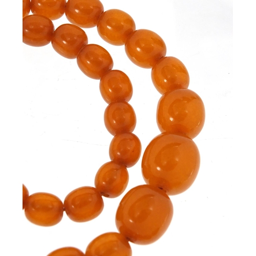 2834 - Amber coloured bead necklace and pendant, the necklace 50cm in length, approximate weight 33.7g