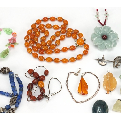 2830 - Polished stone jewellery and amber coloured bead necklaces including Buddha pendants, carved jade pe... 