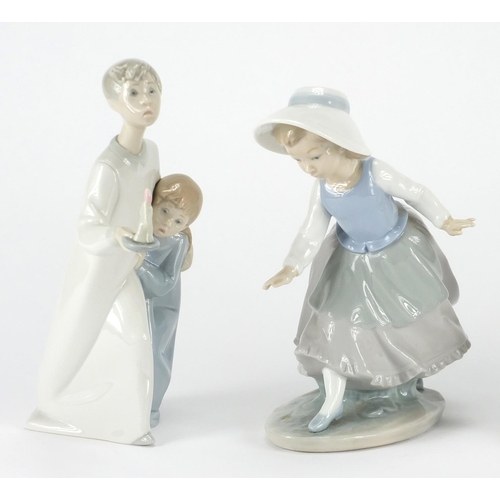 2239 - Three Lladro figuresand one Nao including a girl holding a basket of flowers and a young boy with  g... 