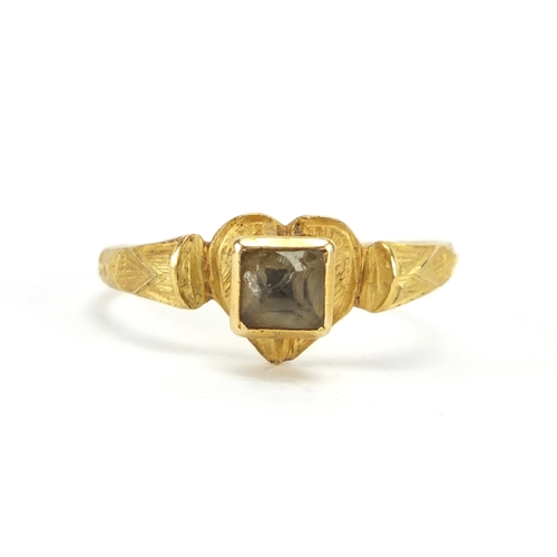 642 - Roman unmarked gold and glass love heart ring, the shoulders with engraved decoration, size J, appro... 