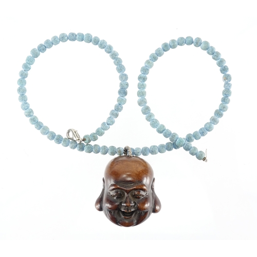 2543 - Japanese carved wooden Noh mask, housed on a blue beaded necklace, the mask 4cm high