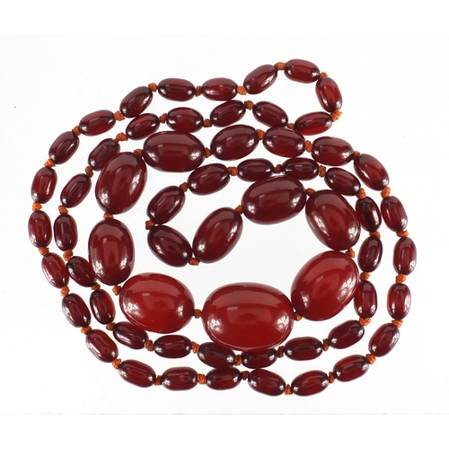 766 - Cherry amber coloured graduated bead necklace, the largest bead approximately 2.7cm wide, 96cm in le... 