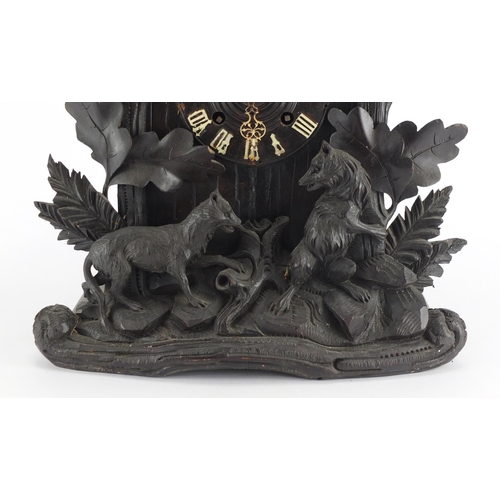 2045 - Black forest cuckoo clock carved with a bear, wolf and leaves, 50cm high