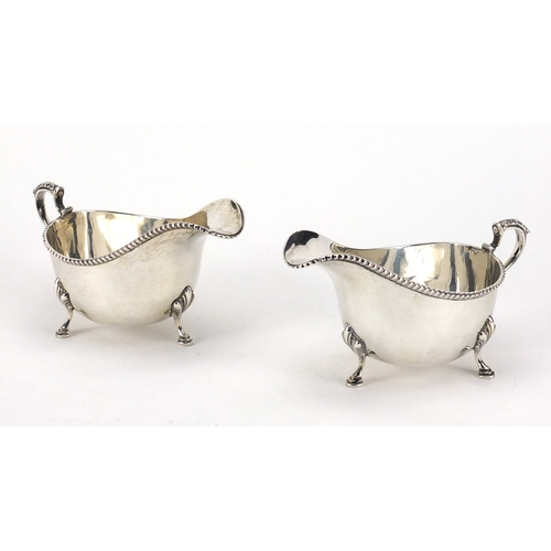 606 - Pair of silver three footed sauce boats, by Mappin & Webb, Birmingham 1929, each 14cm in length, app... 