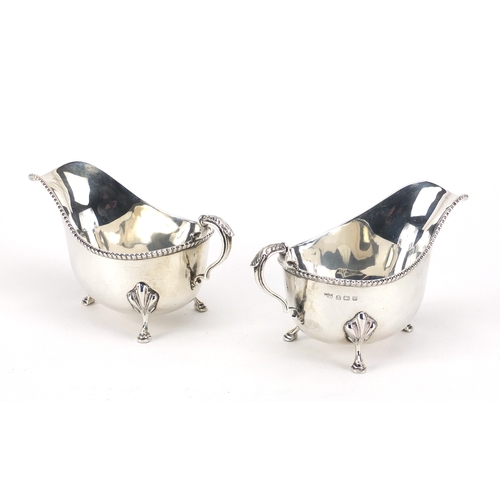 606 - Pair of silver three footed sauce boats, by Mappin & Webb, Birmingham 1929, each 14cm in length, app... 