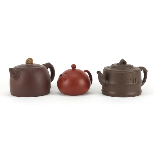 318 - Three Chinese Yixing terracotta teapots including two naturalistic examples, each with character mar... 