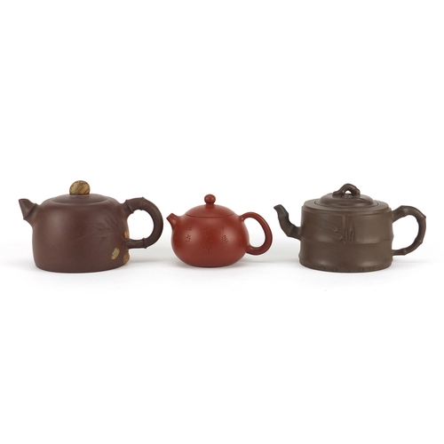 318 - Three Chinese Yixing terracotta teapots including two naturalistic examples, each with character mar... 