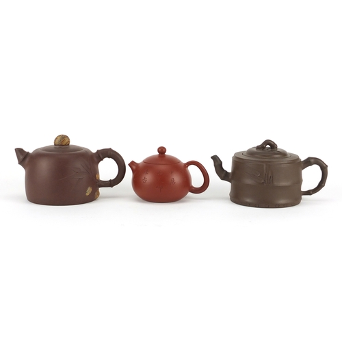 318 - Three Chinese Yixing terracotta teapots including two naturalistic examples, each with character mar... 