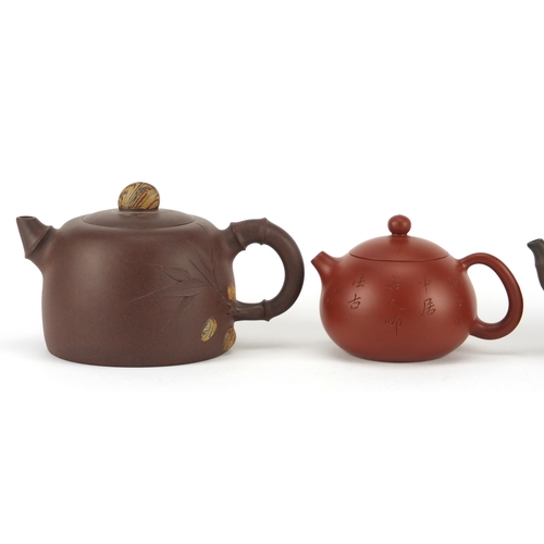 318 - Three Chinese Yixing terracotta teapots including two naturalistic examples, each with character mar... 