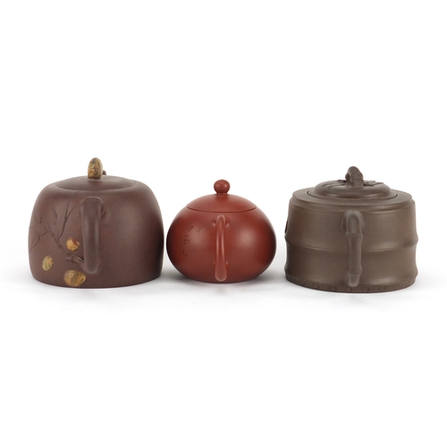 318 - Three Chinese Yixing terracotta teapots including two naturalistic examples, each with character mar... 