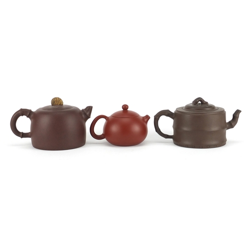 318 - Three Chinese Yixing terracotta teapots including two naturalistic examples, each with character mar... 