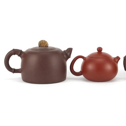 318 - Three Chinese Yixing terracotta teapots including two naturalistic examples, each with character mar... 