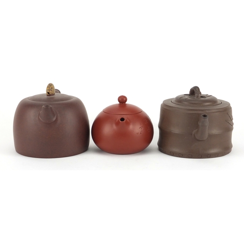 318 - Three Chinese Yixing terracotta teapots including two naturalistic examples, each with character mar... 