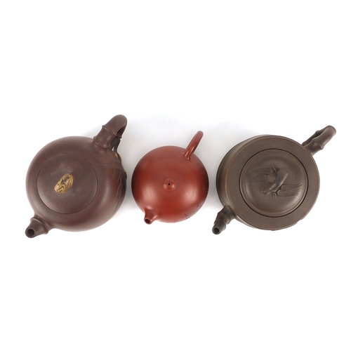 318 - Three Chinese Yixing terracotta teapots including two naturalistic examples, each with character mar... 