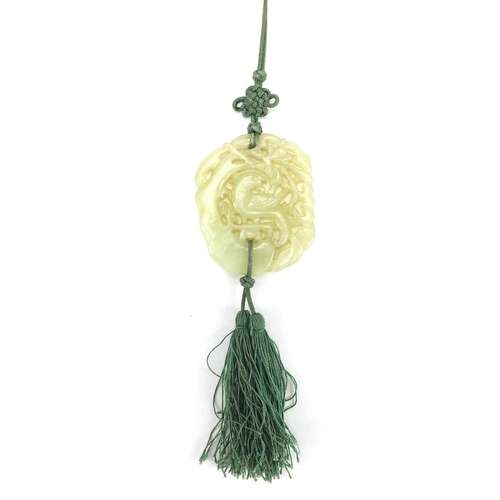 341 - Chinese green jade pendant carved with a bird of paradise on necklace, the pendant 6cm x 5cm