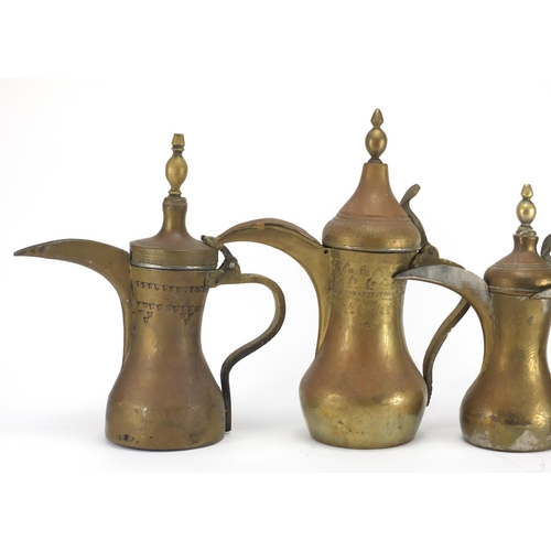 2328 - Four Middle Eastern coffee pots, some with engraved decoration, the largest 37cm high