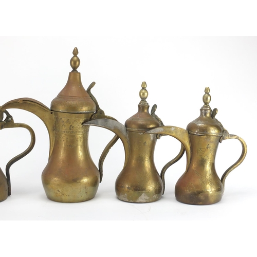 2328 - Four Middle Eastern coffee pots, some with engraved decoration, the largest 37cm high