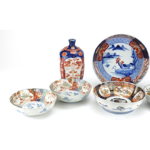 2351 - Japanese porcelain including a pair of vases with square bodies and Imari pattern bowls, one hand pa... 