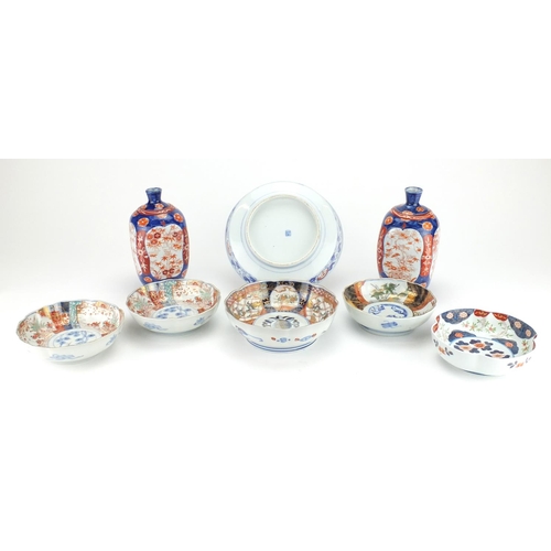 2351 - Japanese porcelain including a pair of vases with square bodies and Imari pattern bowls, one hand pa... 