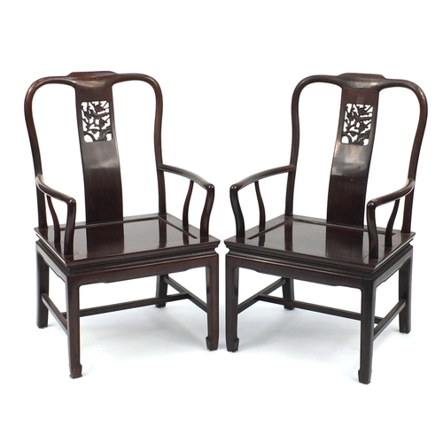2077 - Pair of Chinese hardwood open armchairs carved with prunus flowers, each 96.5cm high
