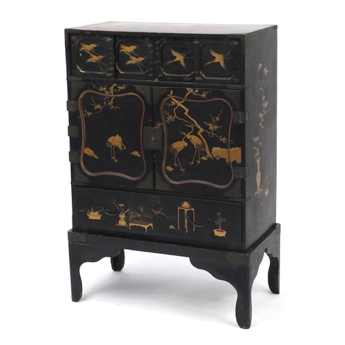 2014 - Black lacquered chinoiserie cabinet on stand, fitted with two pairs of sliding doors above a pair of... 