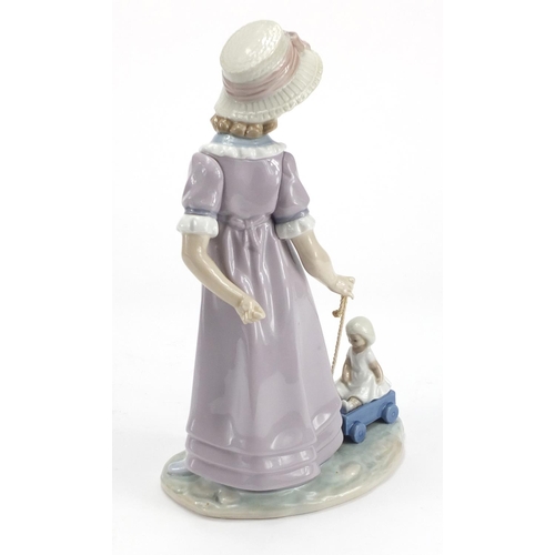 2155 - Lladro figurine of a girl pulling a cart with a doll, 27.5cm high