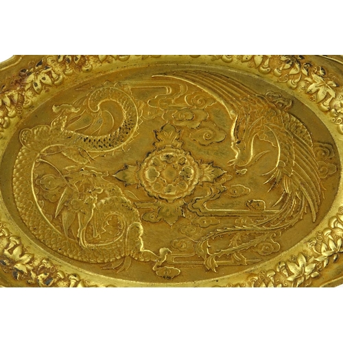 601 - Chinese gilt metal dish cast with a phoenix and dragon, 14.5cm wide