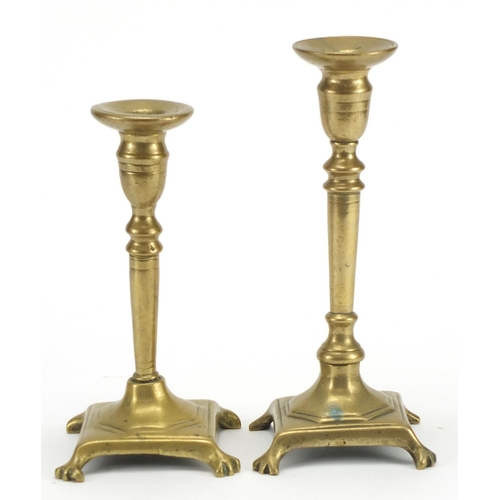 361 - Two antique brass candlesticks with tapering columns and paw feet, the largest 25.5cm high