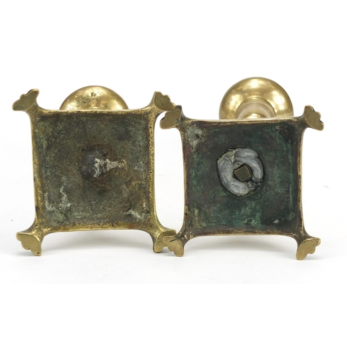 361 - Two antique brass candlesticks with tapering columns and paw feet, the largest 25.5cm high