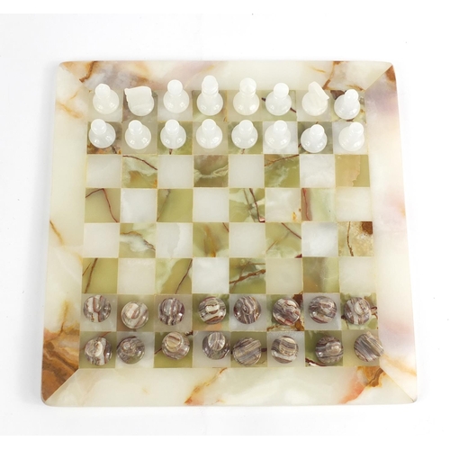 412 - Carved onyx chess set with fitted case, the board 32cm x 32cm