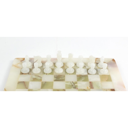 412 - Carved onyx chess set with fitted case, the board 32cm x 32cm