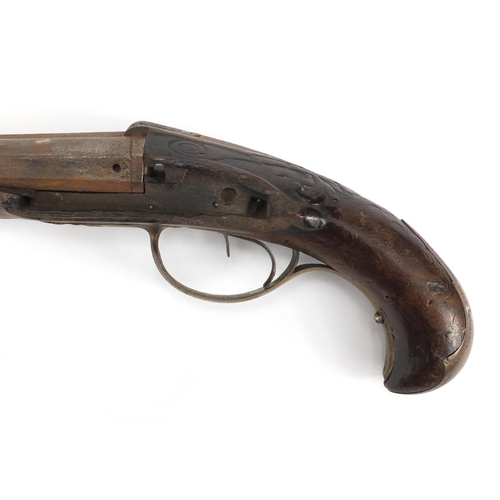 1014 - Antique carved double barrel pistol with brass mounts, 41.5cm in length