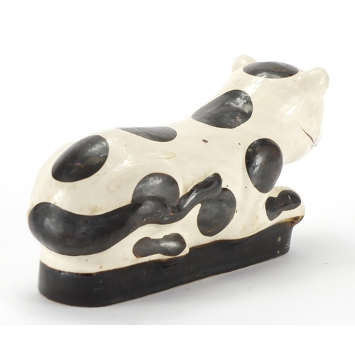 142 - Chinese pottery opium pillow in the form of a recumbent cat, 32cm in length