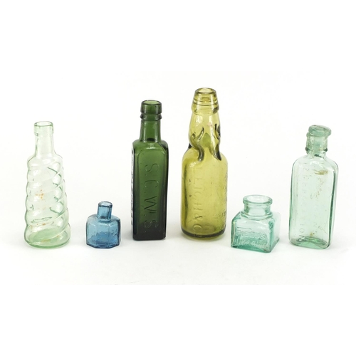 535 - Six antique glass bottles and inkwells including Ellimans Embrocation, Shieldhall Essence of Coffee ... 